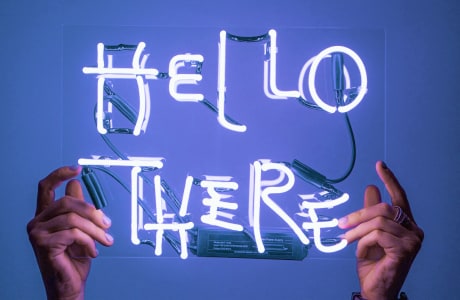 Picture of hands holding a glass rectangle with the words 'Hello There'